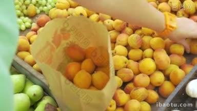 一位妇女在<strong>市场</strong>上买水果，她在柜台上挑选杏子，把它们放进纸袋里
